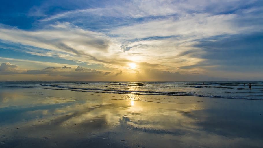 Coqueiros e céu alaranjado ao entardecer em Jericoacoara